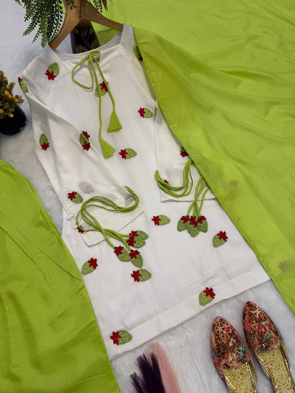 Ethereal Ivory White Short Kurti Adorned with Delicate Floral Embroidery and Tassel Detailing, Paired with a Vibrant Mehendi Green Salwar